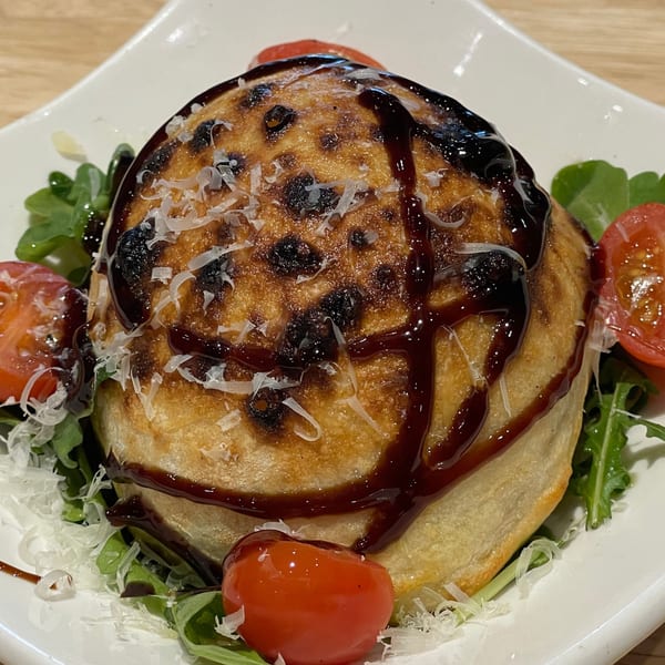 Rodrigo's Craft Pizza calzone, drizzled with balsamic glaze, parmesan, cherry tomatoes, and arugula.