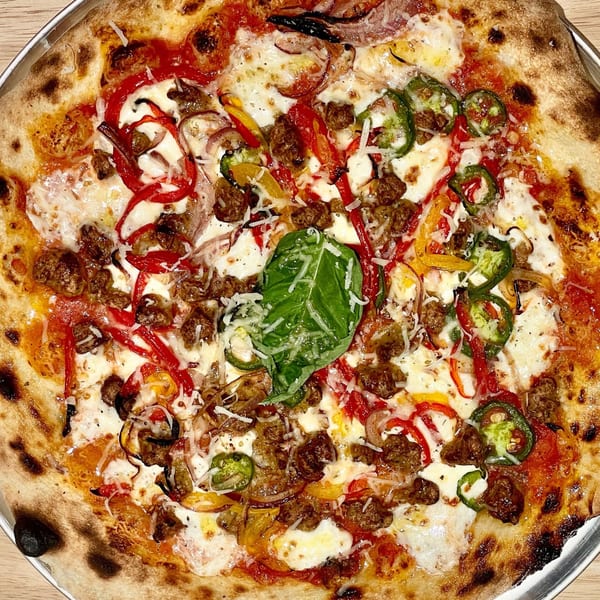 Rodrigo's Craft Pizza with sausage, red and yellow peppers, jalapeños, and basil.